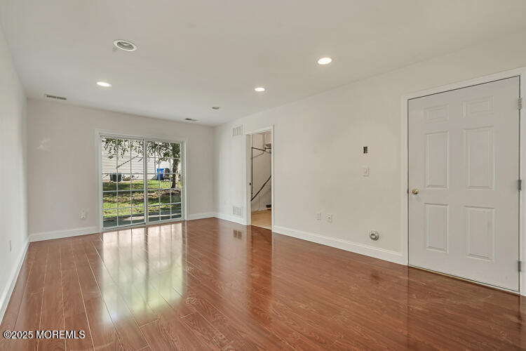 19 Russell Court Matawan, NJ 07747 - Photo 19 of 29 a view of an empty room with wooden floor and a window