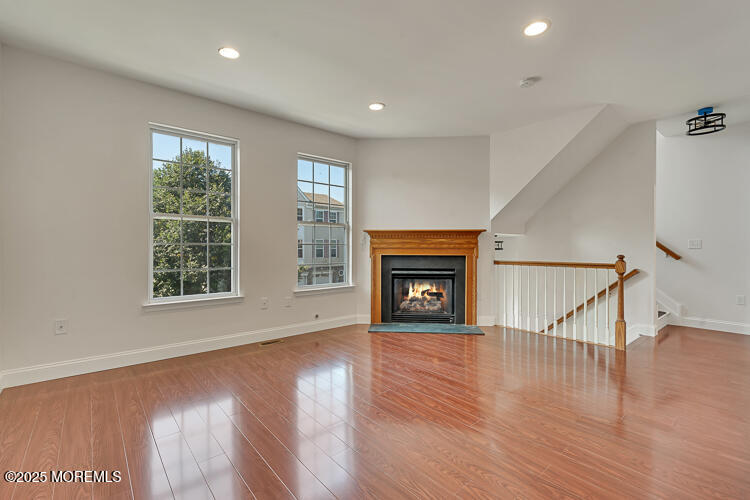 19 Russell Court Matawan, NJ 07747 - Photo 4 of 29 a view of an empty room with wooden floor fireplace and a window