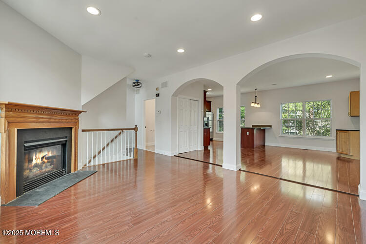19 Russell Court Matawan, NJ 07747 - Photo 6 of 29 a view of a hallway with wooden floor a fireplace and a window