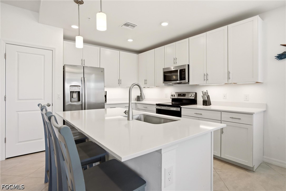 3751 Pebblebrook Ridge Court, Unit 101 Fort Myers, FL 33905 - Photo 4 of 48 a kitchen with a dining table chairs refrigerator and microwave