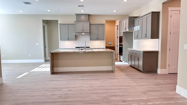 a kitchen with stainless steel appliances a refrigerator and a stove top oven