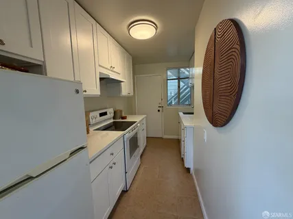 a kitchen with stainless steel appliances granite countertop a sink a stove and a refrigerator