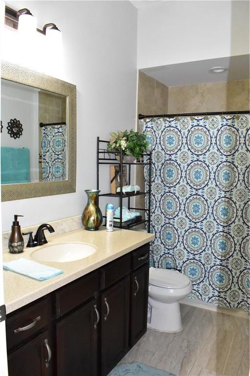 20104 Pond Spring Way Tampa, FL 33647 - Photo 16 of 51 a bathroom with a granite countertop sink and a toilet