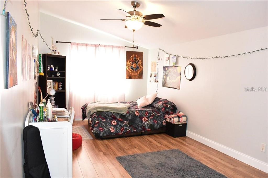 20104 Pond Spring Way Tampa, FL 33647 - Photo 20 of 51 a bedroom with a bed and a chandelier