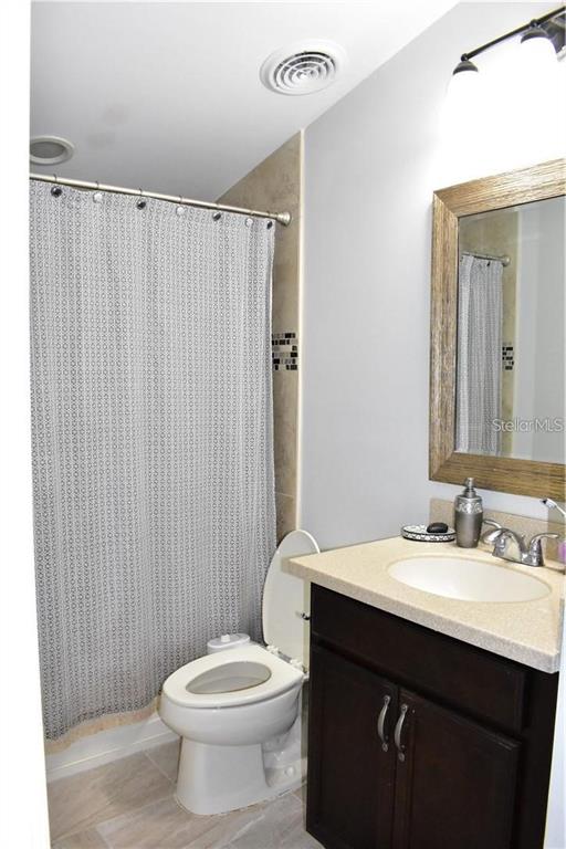 20104 Pond Spring Way Tampa, FL 33647 - Photo 23 of 51 a bathroom with a sink a toilet a mirror and shower curtain