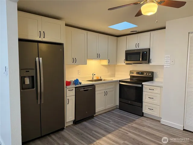 a kitchen with stainless steel appliances granite countertop a refrigerator stove top oven and sink