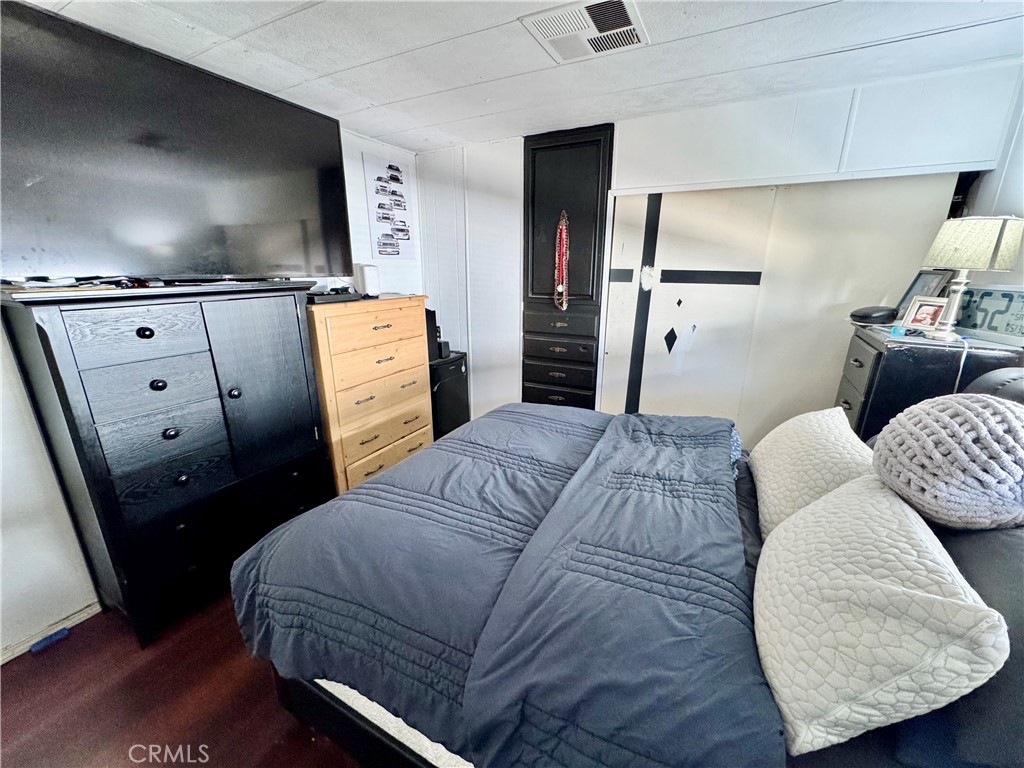 23301 Ridge Rte Drive, Unit 109 Laguna Hills, CA 92653 - Photo 17 of 46 a bedroom with a bed and flat screen tv