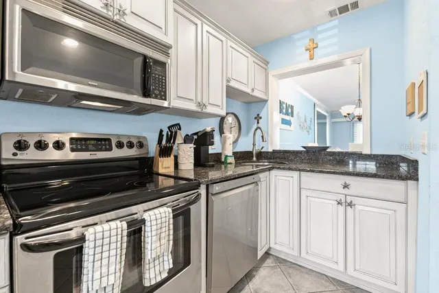 a kitchen with stainless steel appliances granite countertop a stove and a microwave