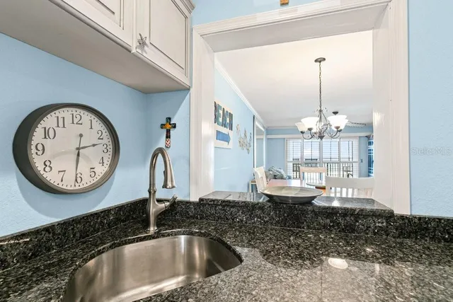 a bathroom with a granite countertop sink and a large mirror