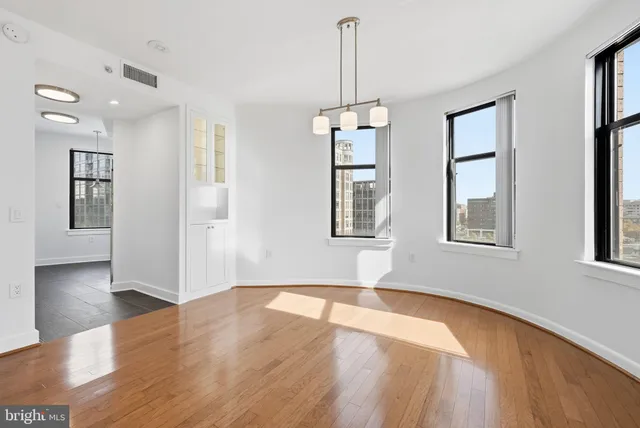 a view of empty room with wooden floor and windows