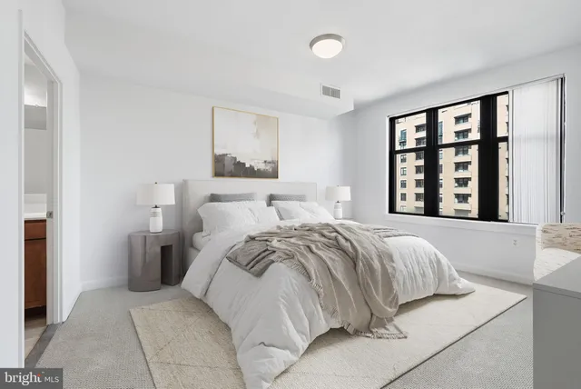 a bedroom with a bed and a large window