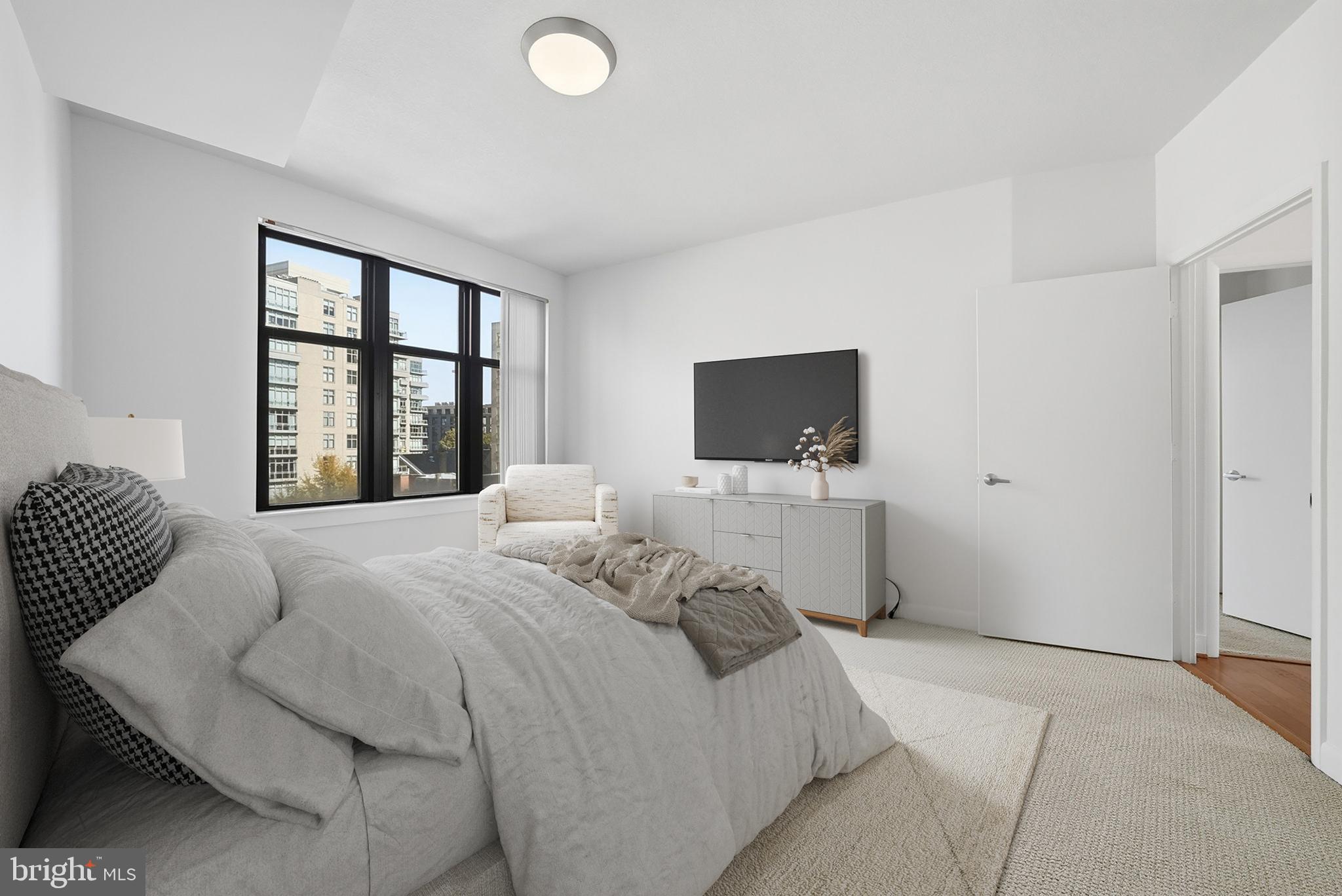 400 Massachusetts Avenue Northwest, Unit 719 Washington, DC 20001 - Photo 23 of 38 a bedroom with a bed and a flat screen tv