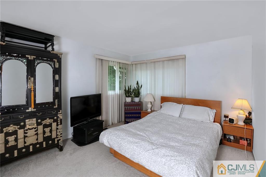 16 Joline Road Kendall Park, NJ 08824 - Photo 13 of 23 a bedroom with a bed and a tv on the dresser