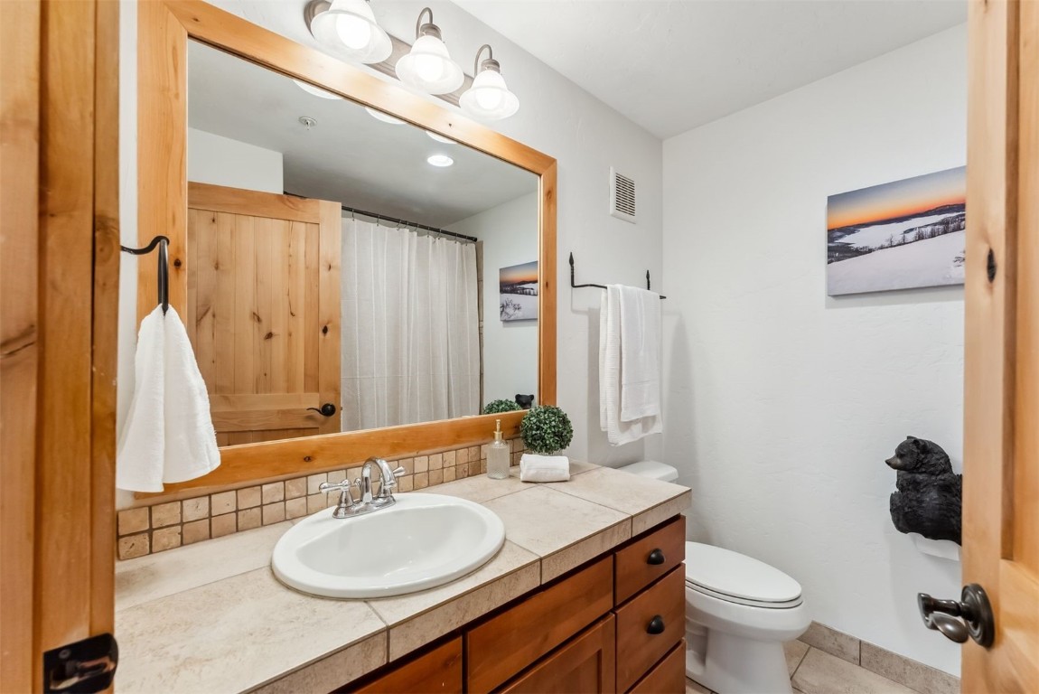 35 Tip Top Trail, Unit 6500 Keystone, CO 80435 - Photo 27 of 47 a bathroom with a granite countertop sink toilet and a mirror