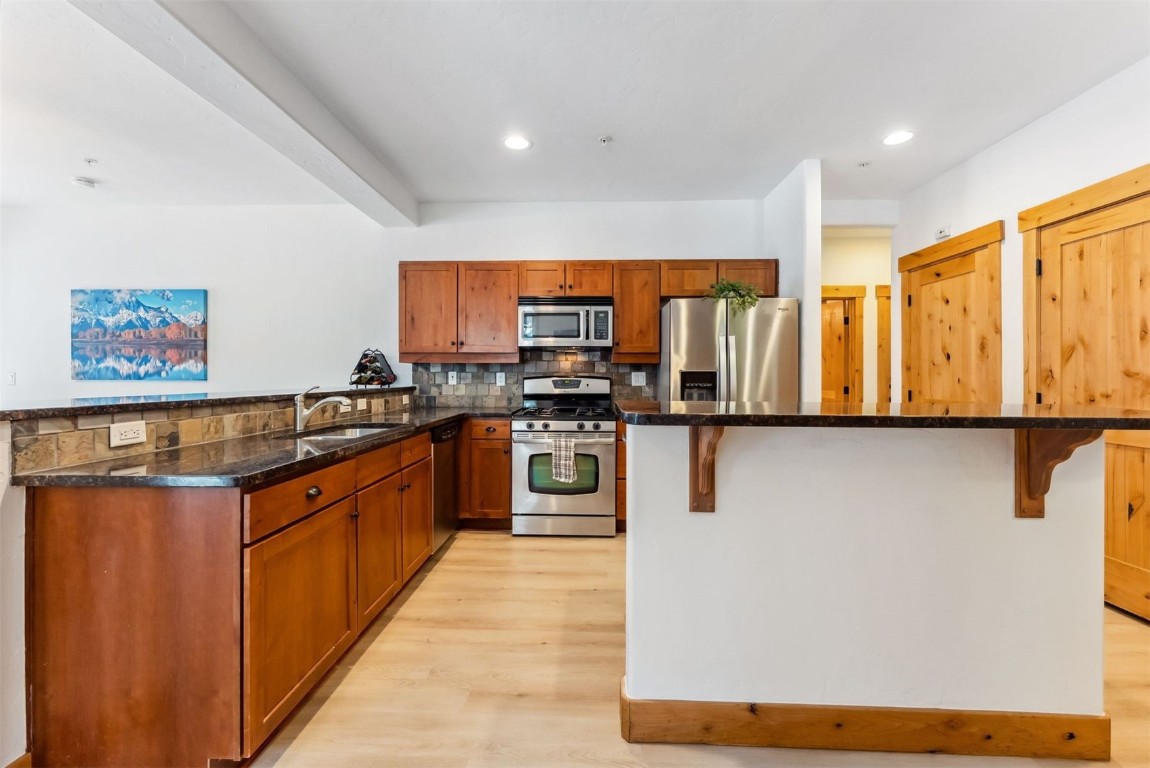 35 Tip Top Trail, Unit 6500 Keystone, CO 80435 - Photo 7 of 47 a kitchen with stainless steel appliances granite countertop a stove a sink and a refrigerator