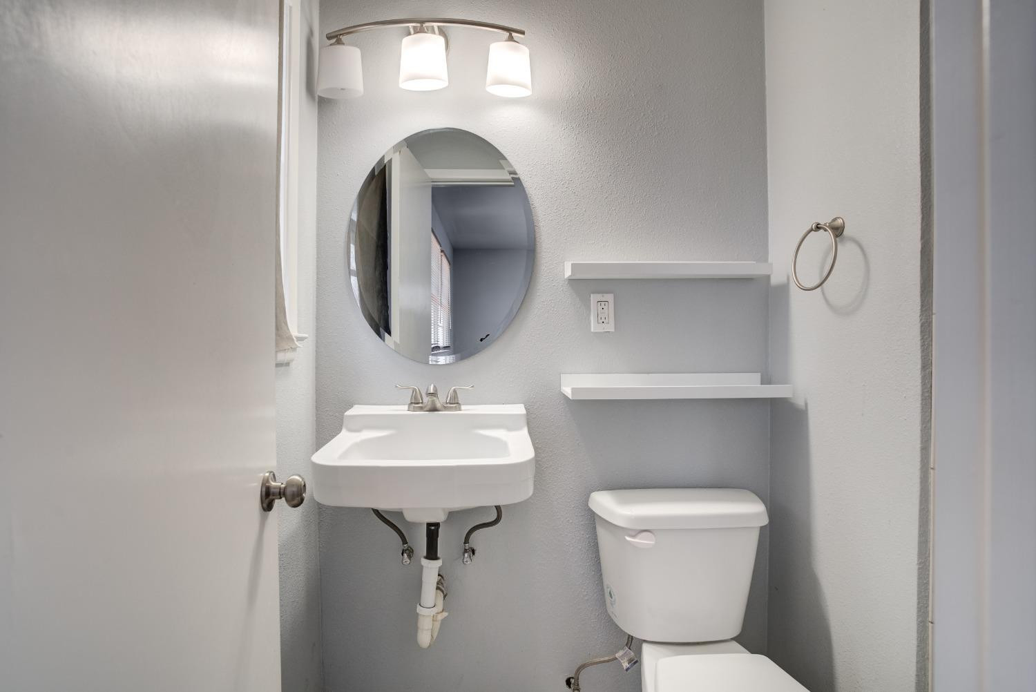 3011 44th Street Lubbock, TX 79413 - Photo 16 of 19 a bathroom with a toilet sink and mirror