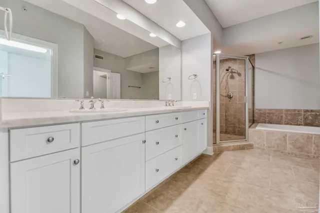 a spacious bathroom with double sink a large mirror and a shower