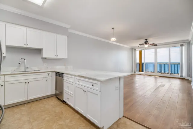 a view of a kitchen with granite countertop white cabinets and wooden floor