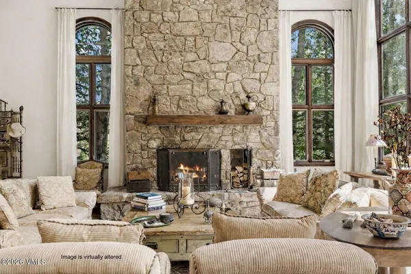 a living room with furniture chandelier and a large window