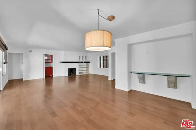 a view of a room with wooden floor and chandelier