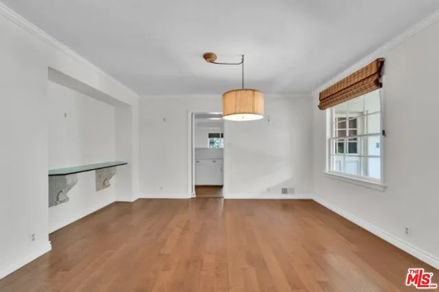 a view of empty room with wooden floor and window