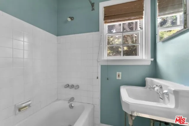 a bathroom with a sink a bathtub and a window