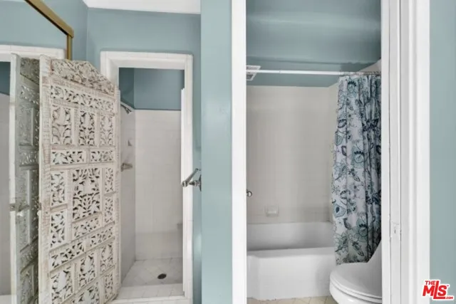 a bathroom with a shower curtain and a toilet