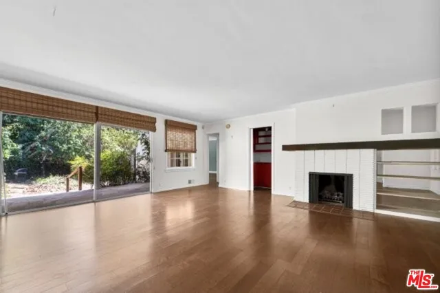 wooden floor fireplace and windows in an empty room