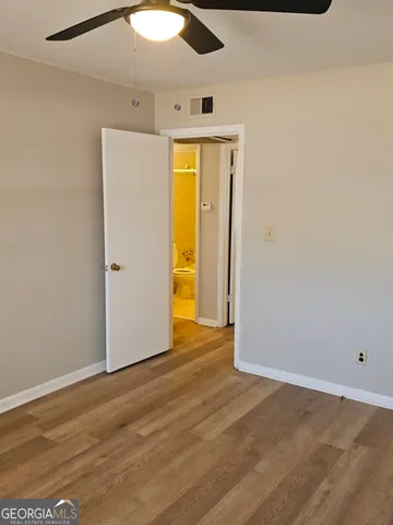an empty room with wooden floor and natural light