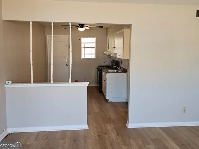 a view of a kitchen with wooden floor and a sink