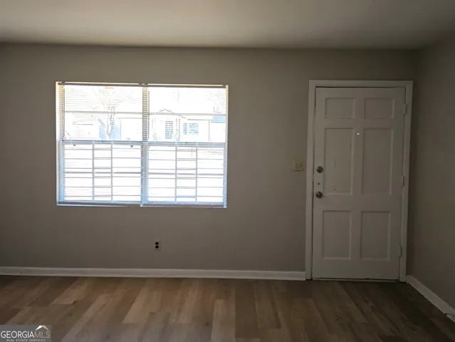 an empty room with wooden floor and window