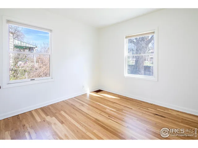 a view of an empty room and wooden floor