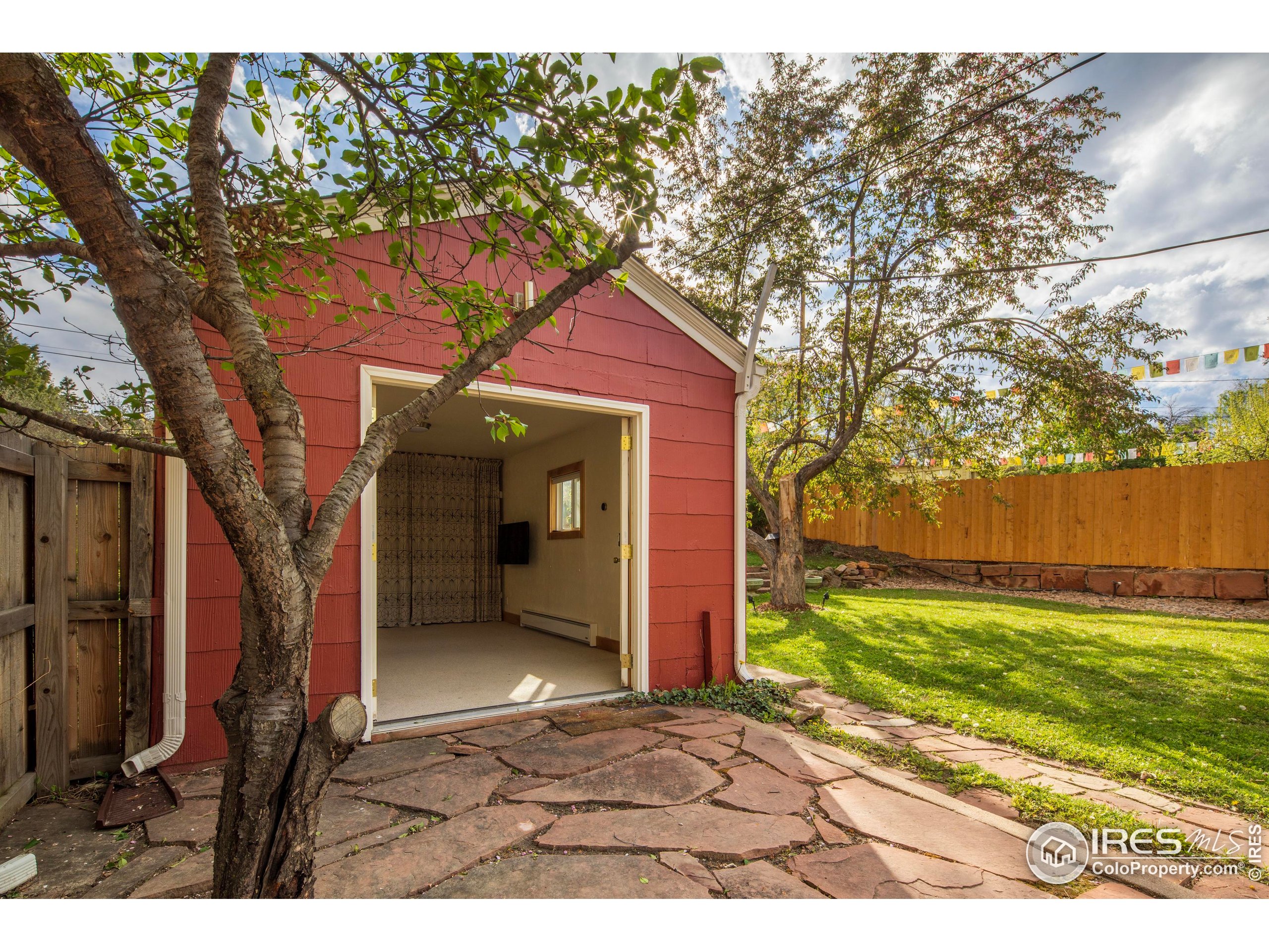 2447 20th Street Boulder, CO 80304 - Photo 21 of 35 a backyard of a house with a yard and large tree