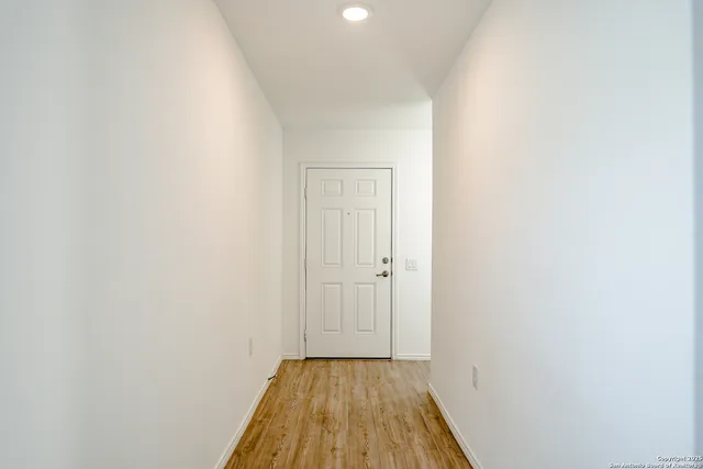 a view of a hallway with wooden floor