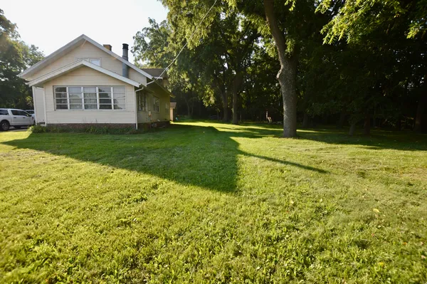 a view of a house with a yard and a tree
