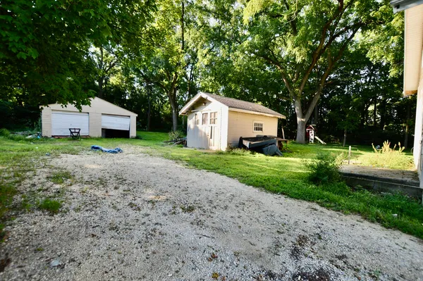 a front view of a house with a yard and large trees