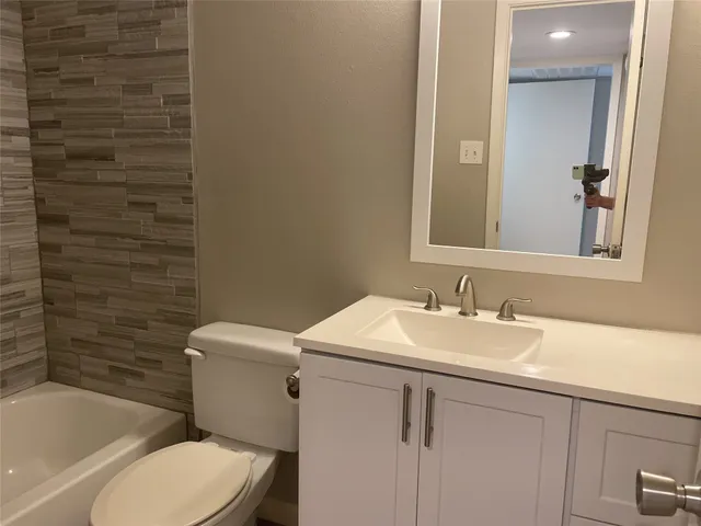 a bathroom with a sink a toilet and bathtub