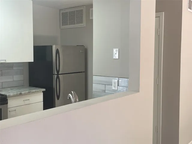 a kitchen with a refrigerator and cabinets
