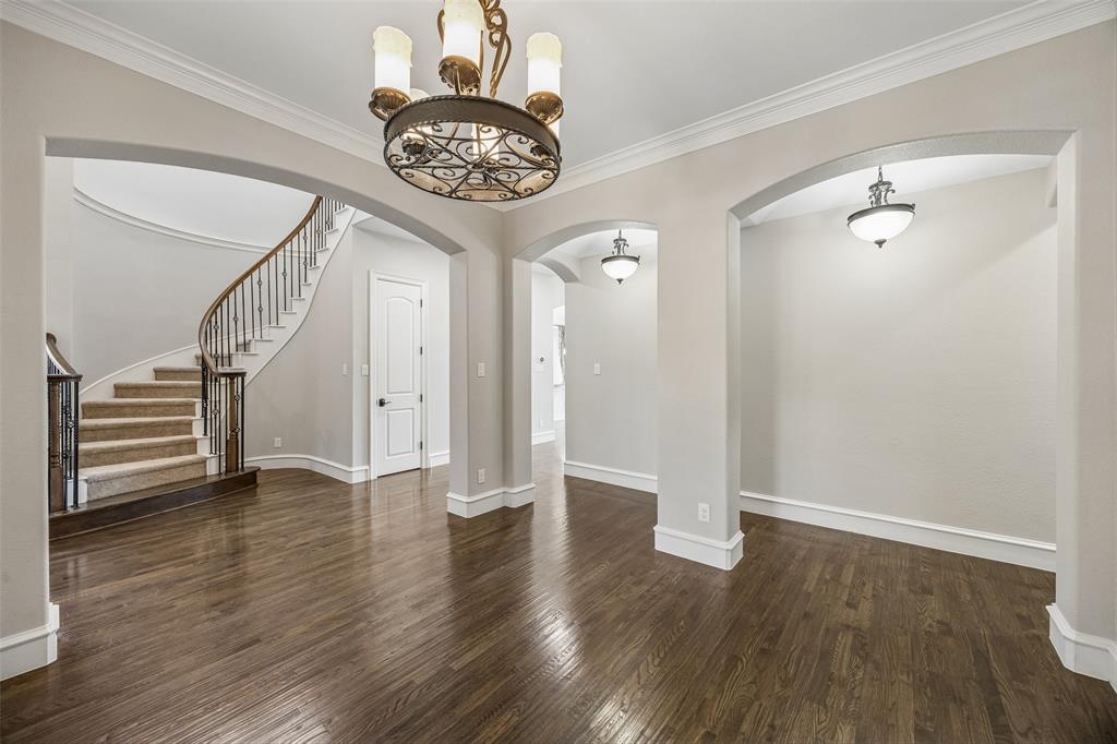 134 Santa Rosa Way Irving, TX 75062 - Photo 11 of 26 Elegant dining room featuring a statement chandelier, rich wood floors, and graceful architectural details.
