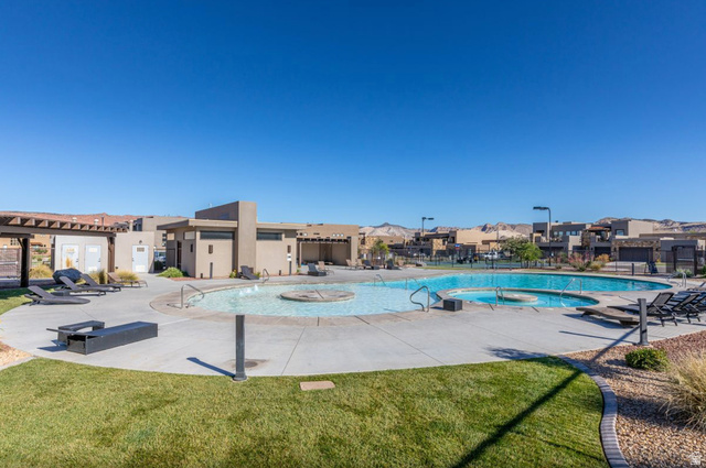 1622 Canyon Tree Drive St. George, UT 84770 - Photo 31 of 34 Community swimming pool with an integrated spa, surrounded by a concrete deck and manicured lawn