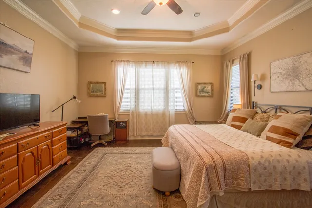 a bedroom with a bed and a flat tv screen on dresser