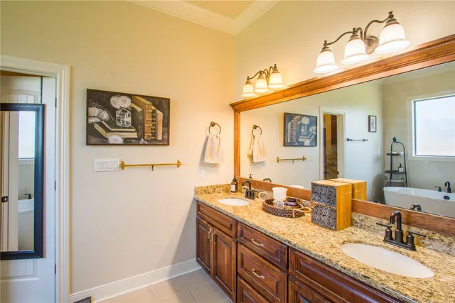 a bathroom with a granite countertop double vanity sink and two mirror