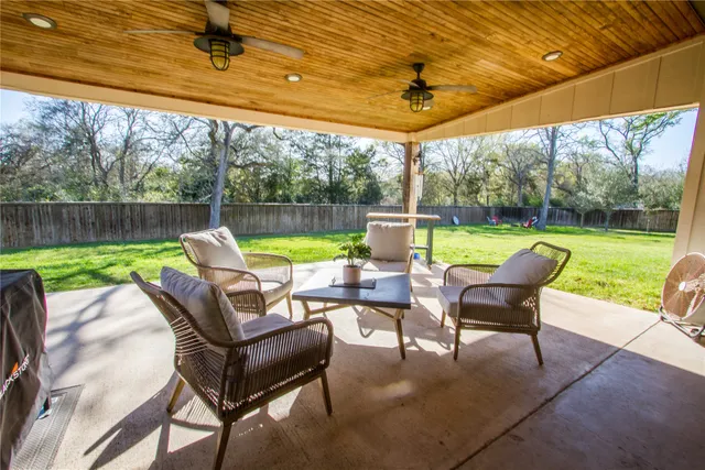 a view of a swimming pool with a table and chairs in patio