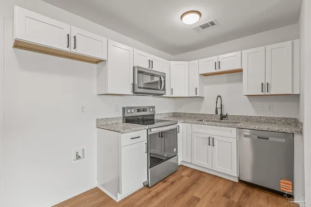 a kitchen with stainless steel appliances granite countertop a sink and cabinets