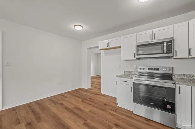 a kitchen with a stove and white cabinets