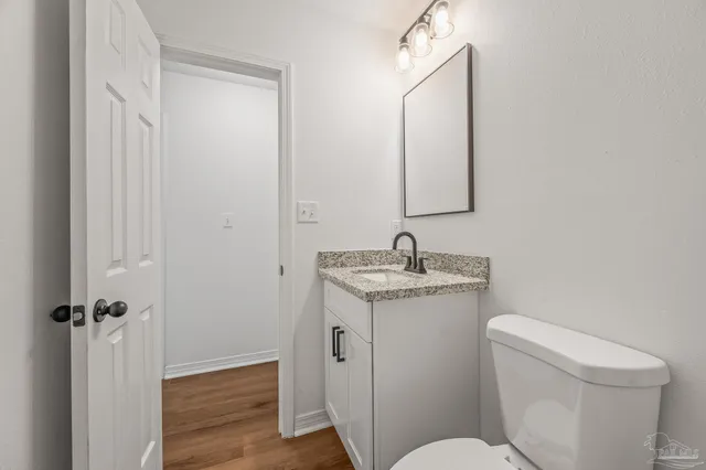 a bathroom with a granite countertop toilet sink and mirror