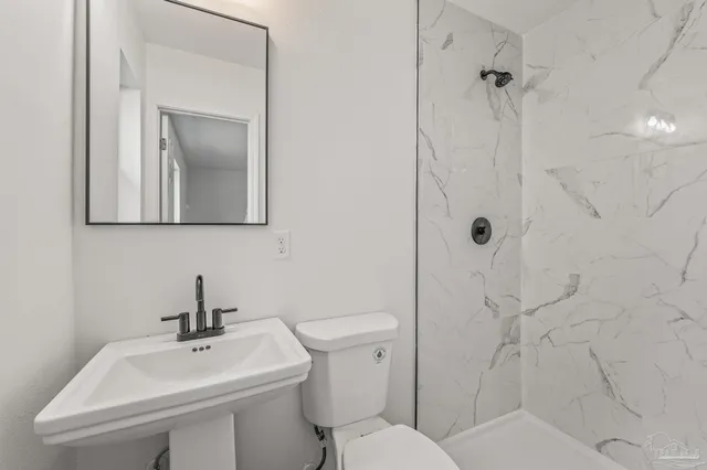 a bathroom with a shower and a toilet sink