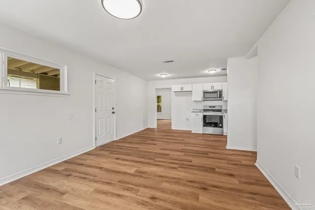 a view of empty room with wooden floor