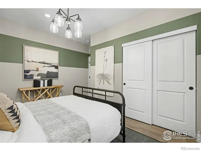 a bedroom with a large bed couch and windows