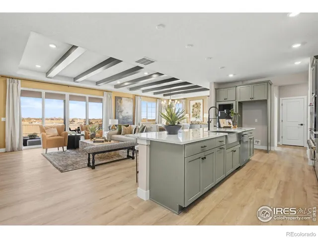 a kitchen with kitchen island granite countertop a sink cabinets and wooden floor